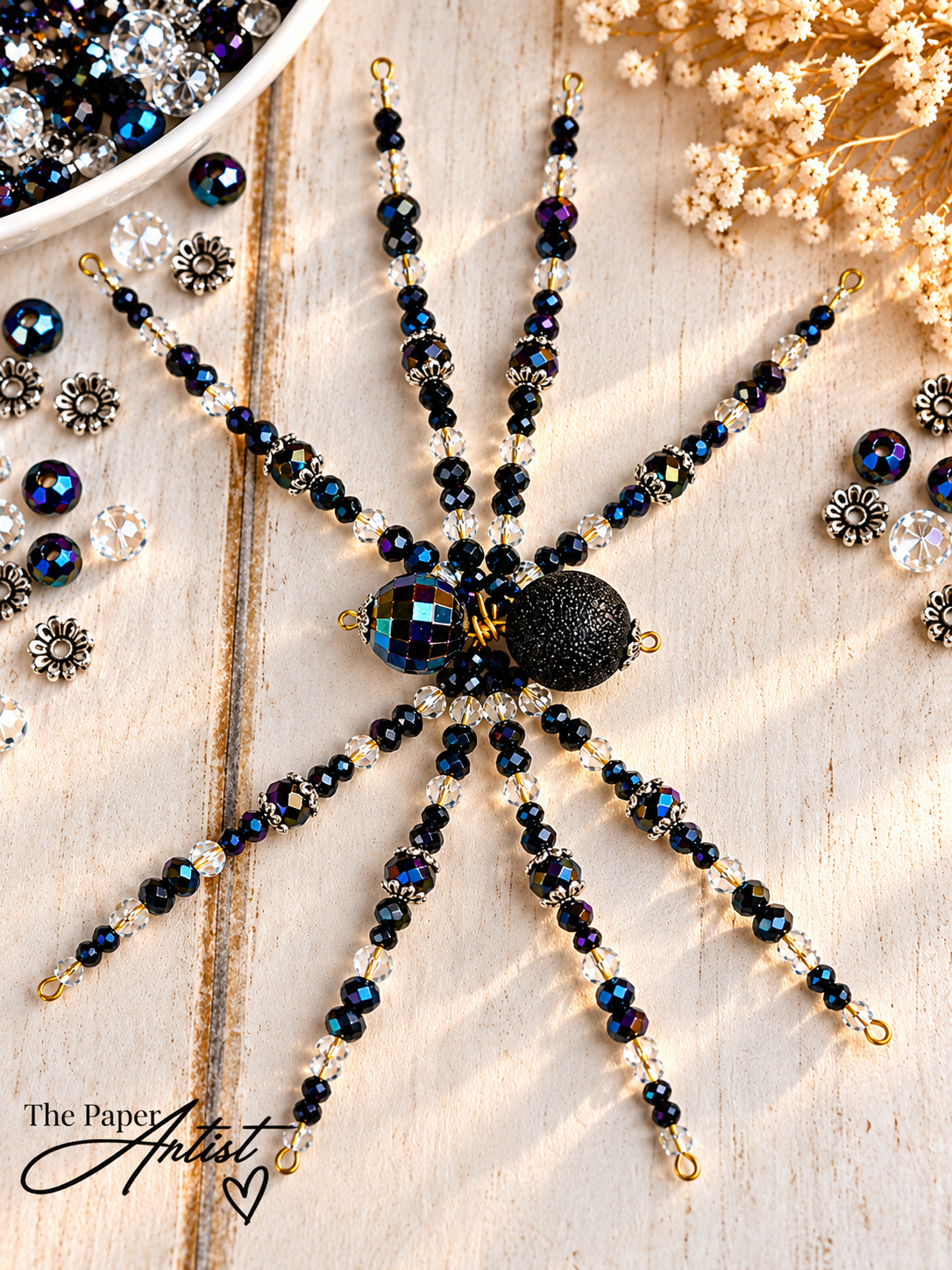 Handmade beaded spider with eight completed legs before shaping