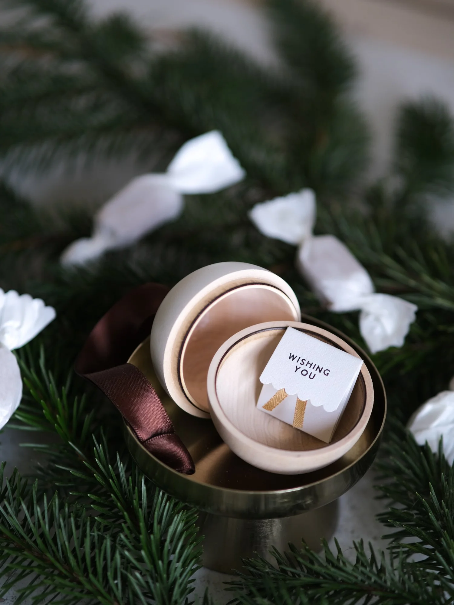 Wooden and white Christmas gift bauble with a removable lid, hanging from a Christmas tree with a space inside for a handwritten message, gift or surprise.