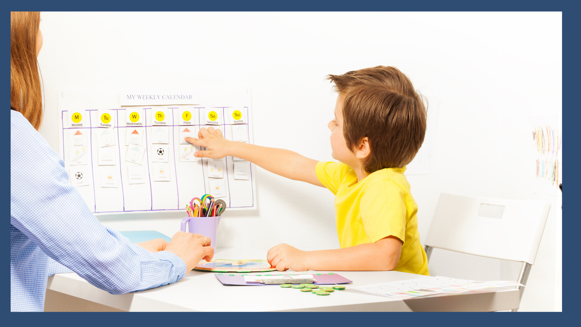 A young boy pointing to a colorful weekly calendar on the wall with an adult, representing visual planning tools and structured routines that support executive functioning development in children