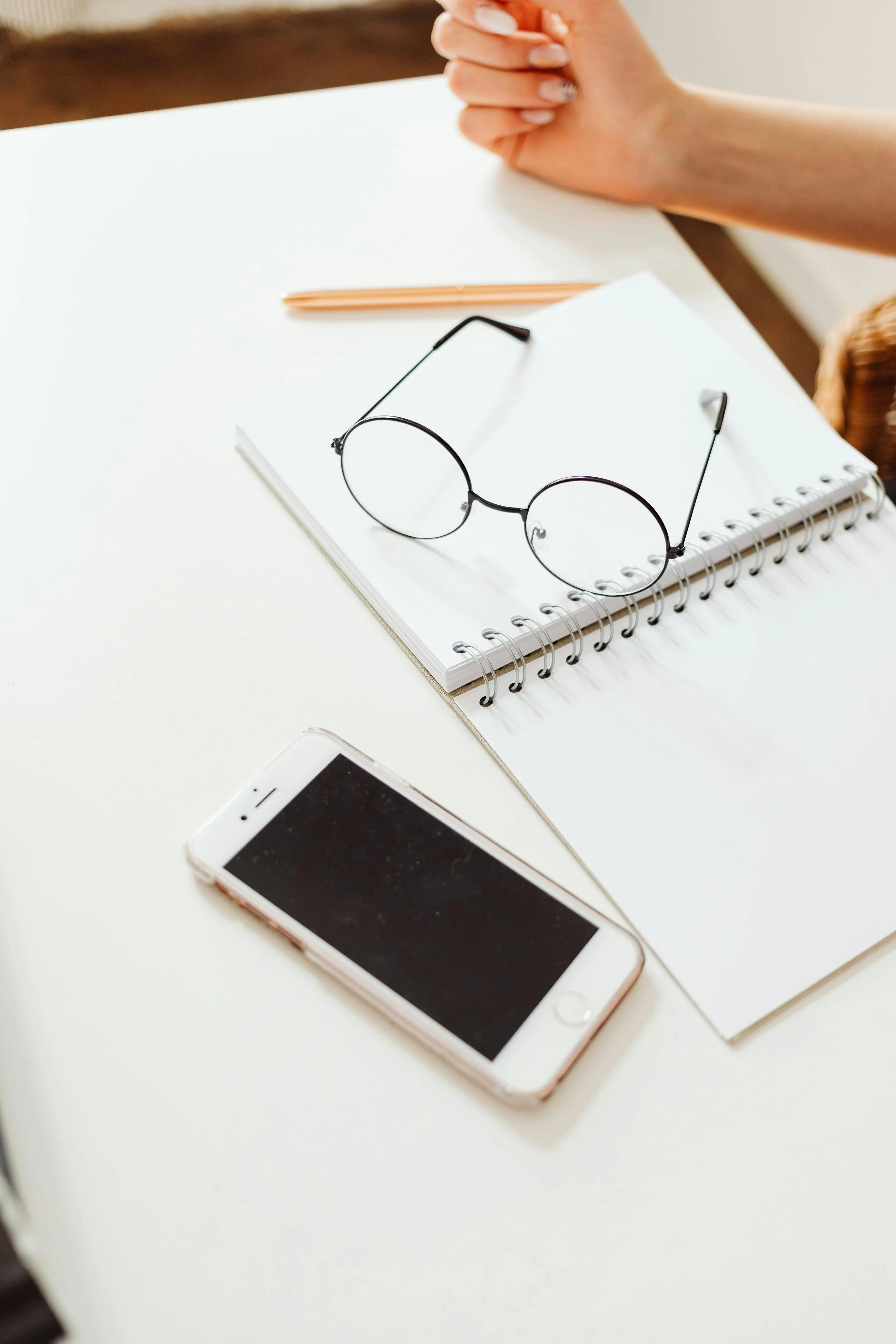 Desk flatlay with notebook, glasses, and phone representing a therapeutic recreation and counseling discovery call consultation for Executive Functioning Coaching and DD Waiver Services at Restoration and Recreation