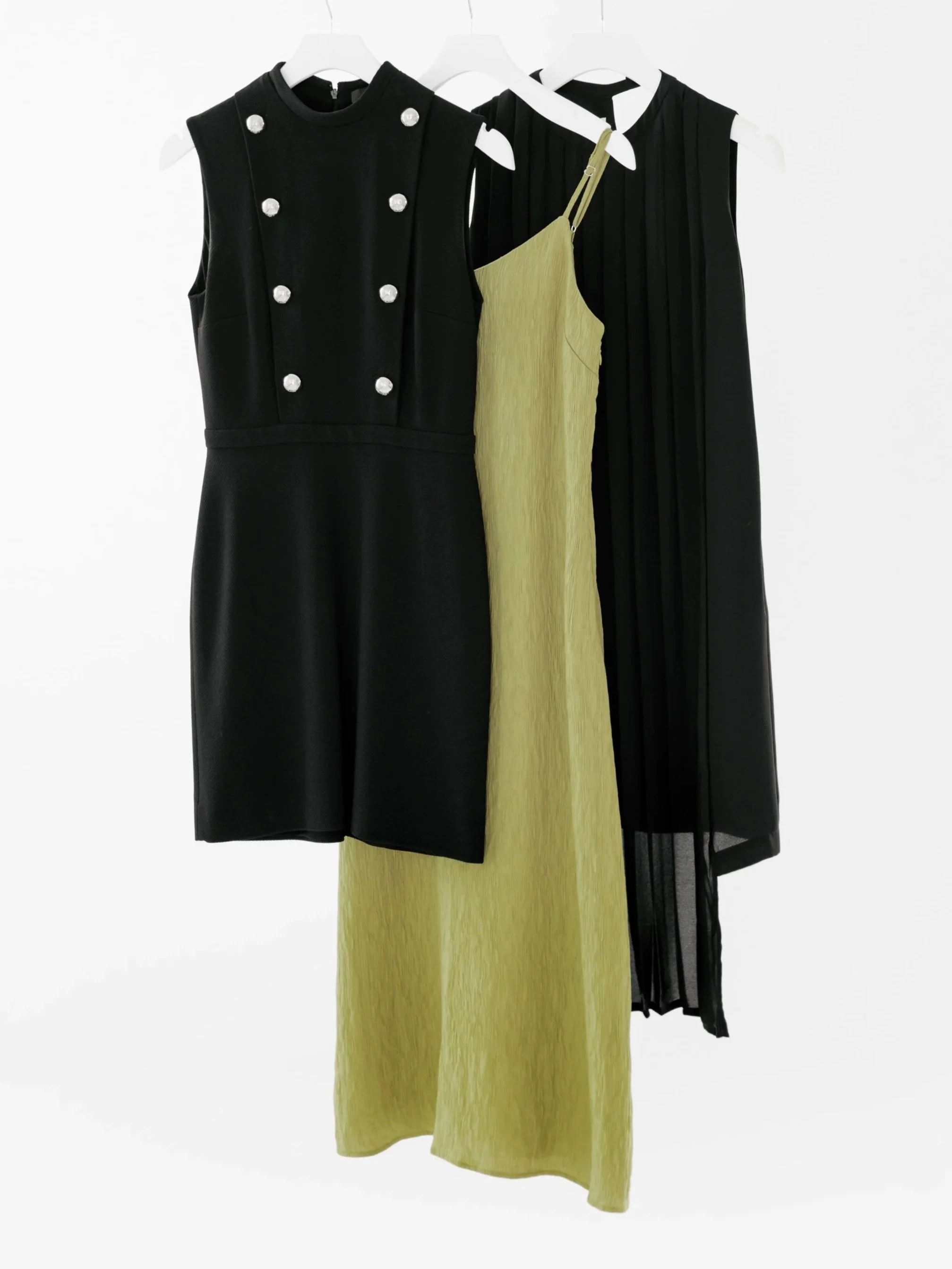 Three luxury dresses on hangers in front of a white background. DistriktF Park City Fashion and Wardrobe Styling