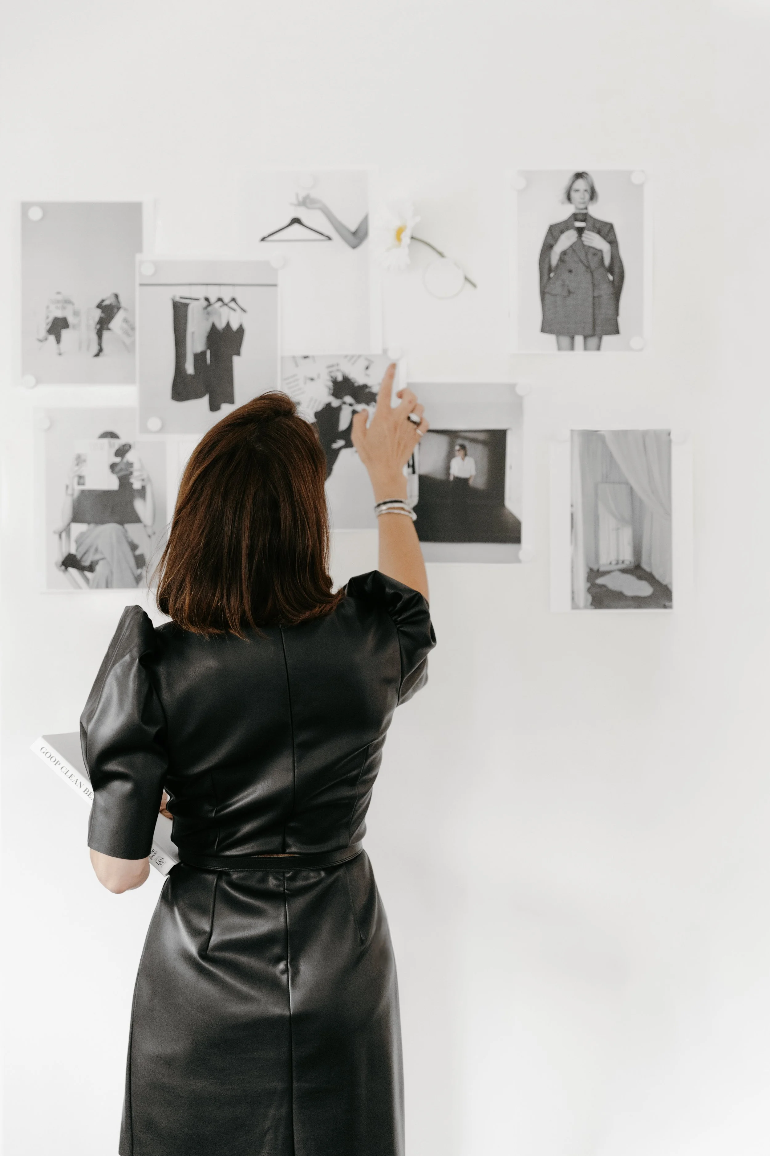 Stylist looking through printed inspiration images on wall.  DistriktF Park City. Vanessa Di Palma Wright, Farasha.