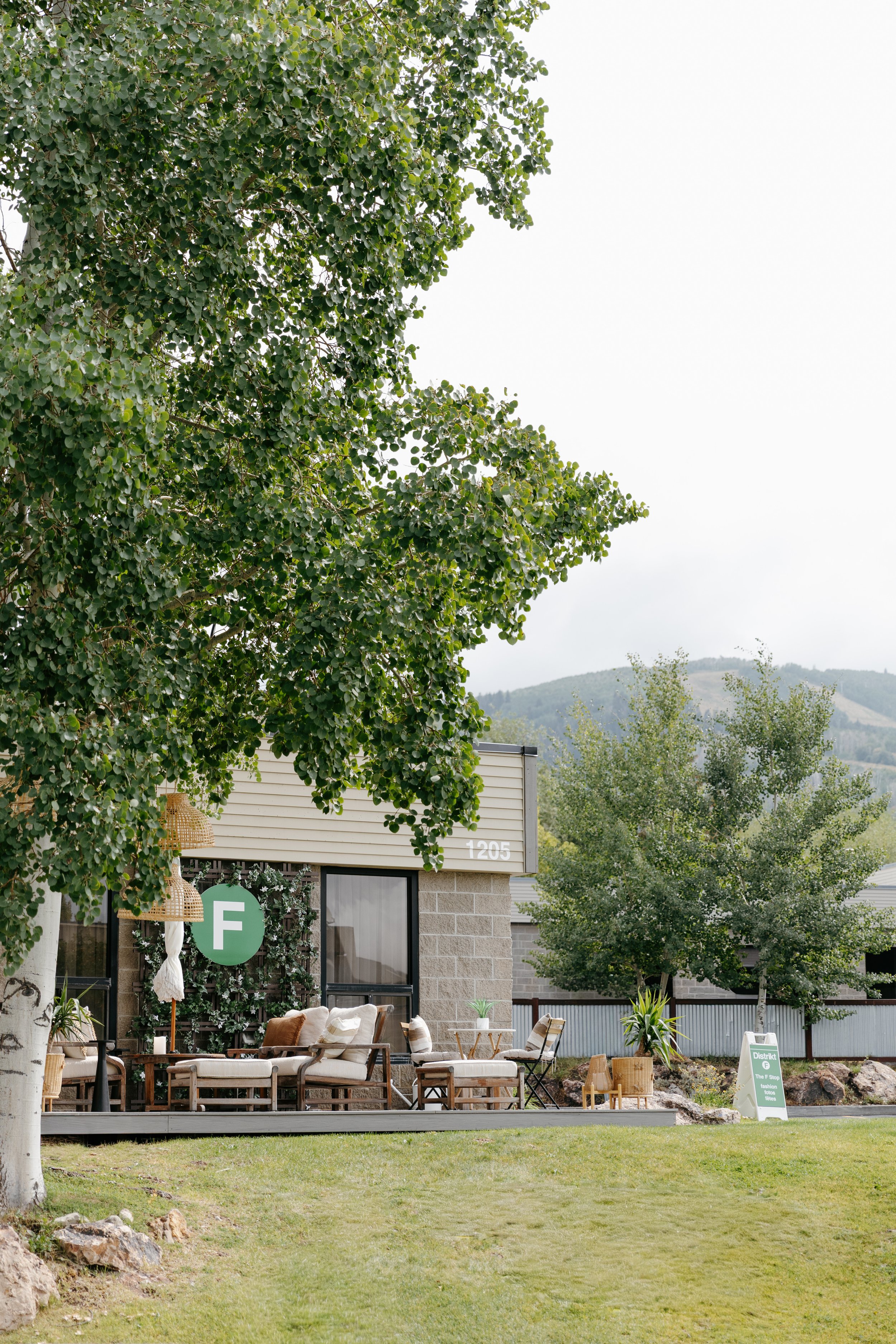 Outside of the Distrikt F building with lush green foliage and a mountain backdrop. DistriktF Park City Brand Pop-Up Rental Space