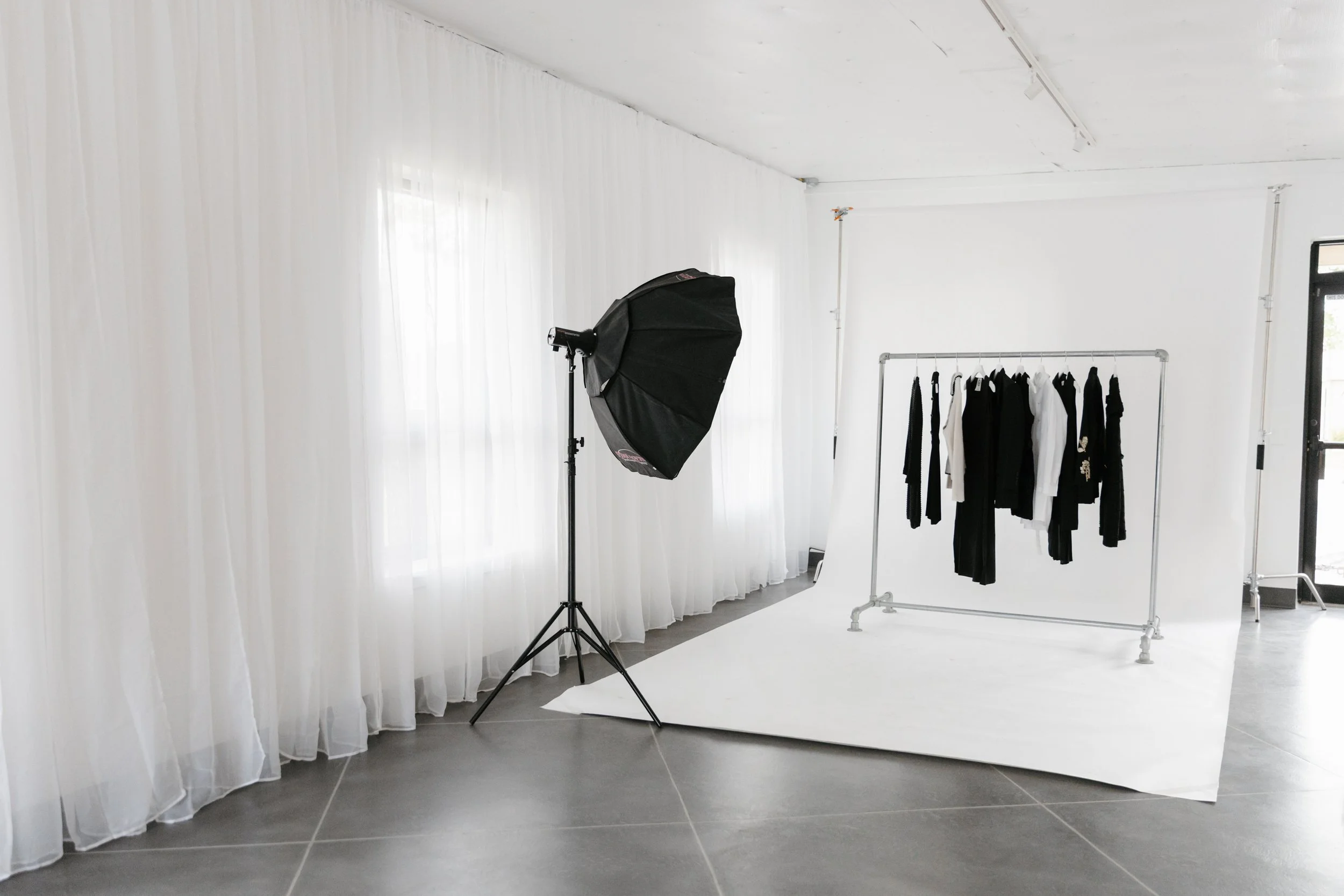 Bright, modern, and airy photo studio with a clothing rack and professional lighting. DistriktF Park City Indoor Photo Studio Rental.