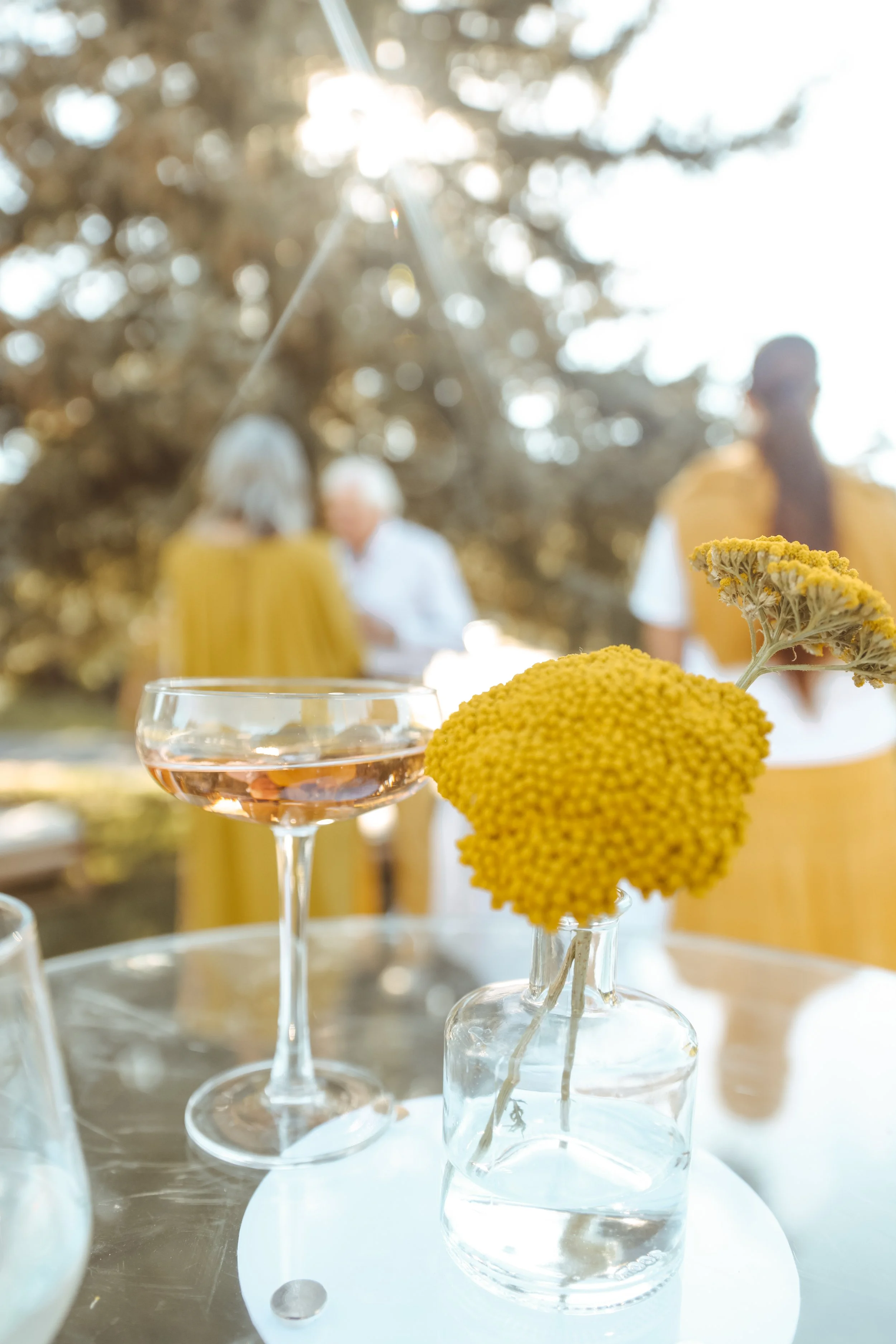 Seasonal flowers and elevated cocktail glass on a table at an event. DistriktF Park City Event Space Rental.
