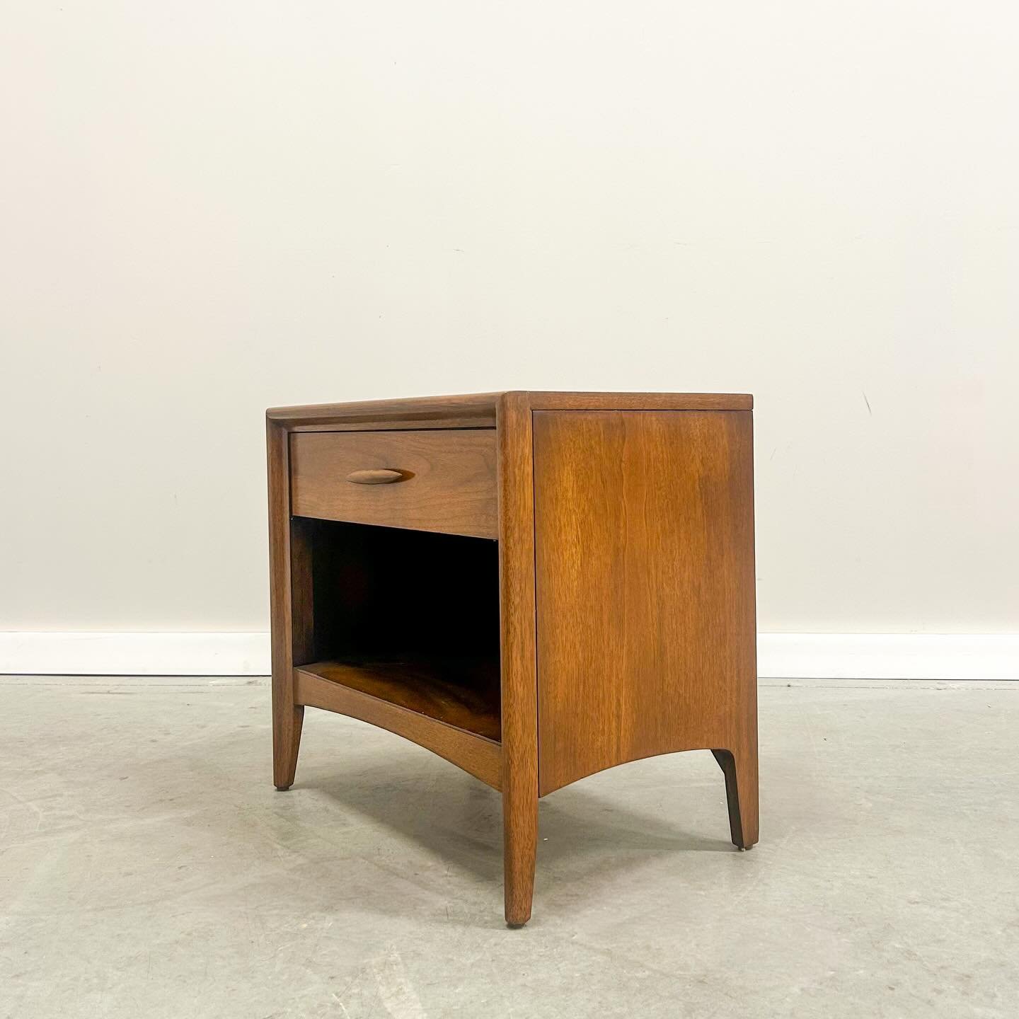 This refinished Broyhill Emphasis nightstand showcases rich walnut grain, a smooth gliding drawer, and new floor glides making it a timeless mid-century staple. The open shelf even leaves room for your decor or a curious cat keeping a respectful eye.