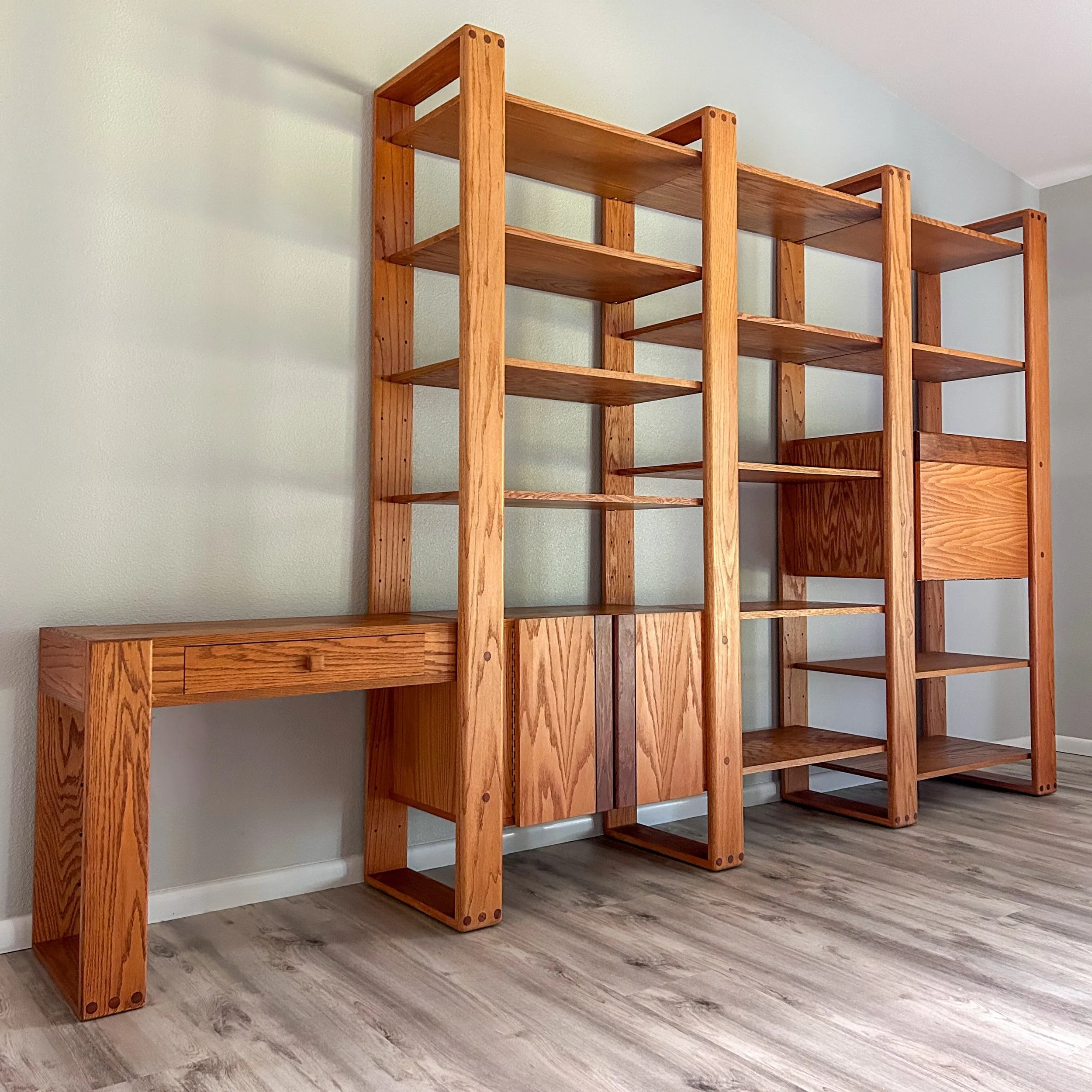 So excited to share this 1970s modular wall unit designed by Lou Hodges for California Design Group. Made of solid oak with walnut details on the drawer and doors. Thirteen shelves to customize as you see fit, plus a cute little writing desk. Finishe
