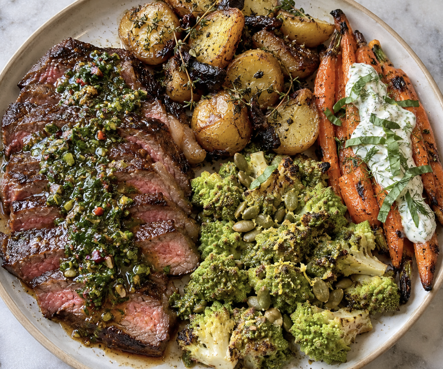 Steak or lamb with Brown Marrow Butter and Chimichurri, Roasted Thyme Potatoes with Black Garlic, Grilled Carrots with Basil-Dill Crème Fraîche, and Roasted Romanesco with Pepita Pesto