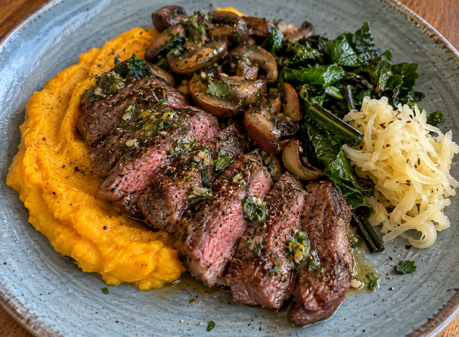 Grass-Fed Strip Steak with Kabocha Purée, Sautéed Mushrooms, Wilted Greens, and Raw Sauerkraut