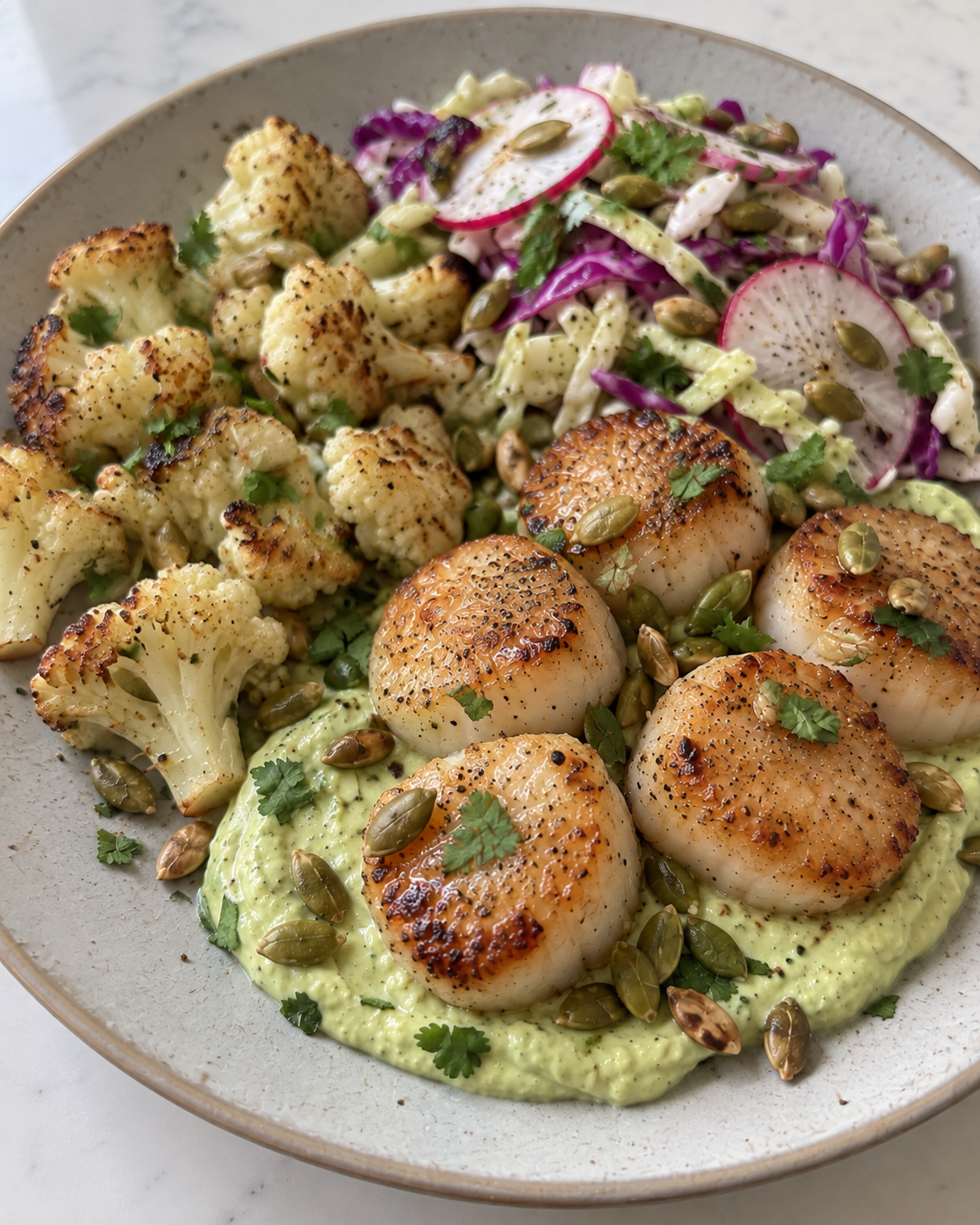 Seared Scallops with Avocado-Lime Crema, Roasted Cauliflower, Cabbage-Radish Slaw, and Toasted Pepitas