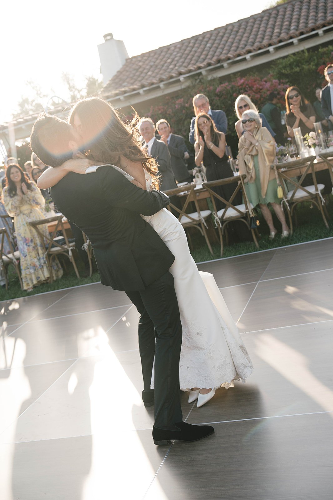  The newlyweds share a kiss after their first dance as bride and groom. Digital. 