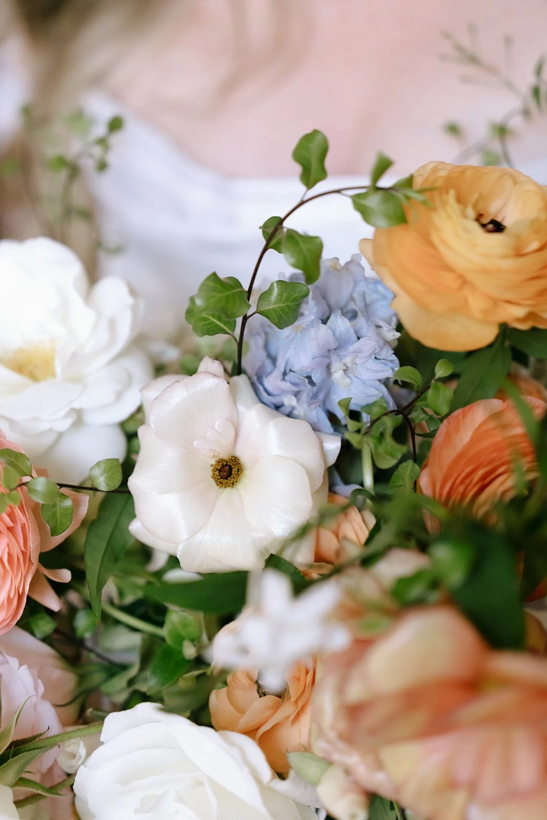 Pink, white, blue, yellow, and orange flowers in the garden-inspired bridal bouquet.