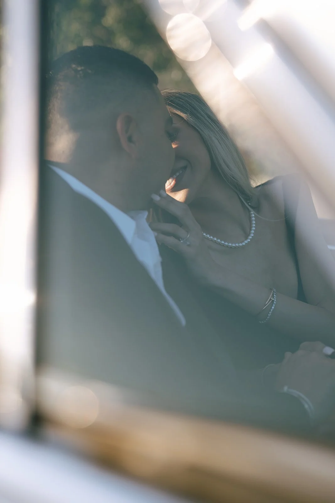 Leaning in for a kiss through the glass Cadillac window.