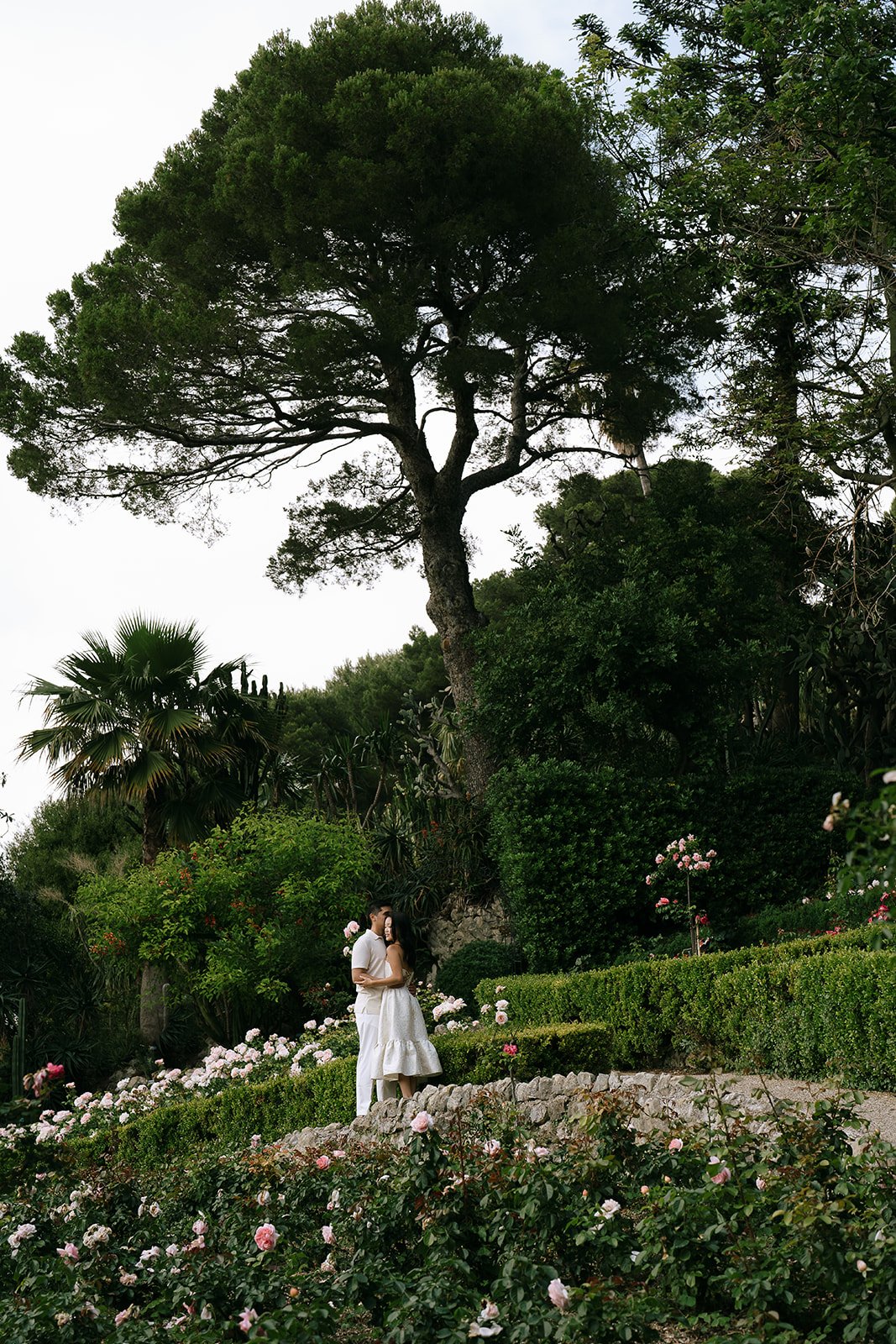 Soon to be bride and groom embracing in the Rose garden of the Villa Ephrussi during their destination engagement photoshoot