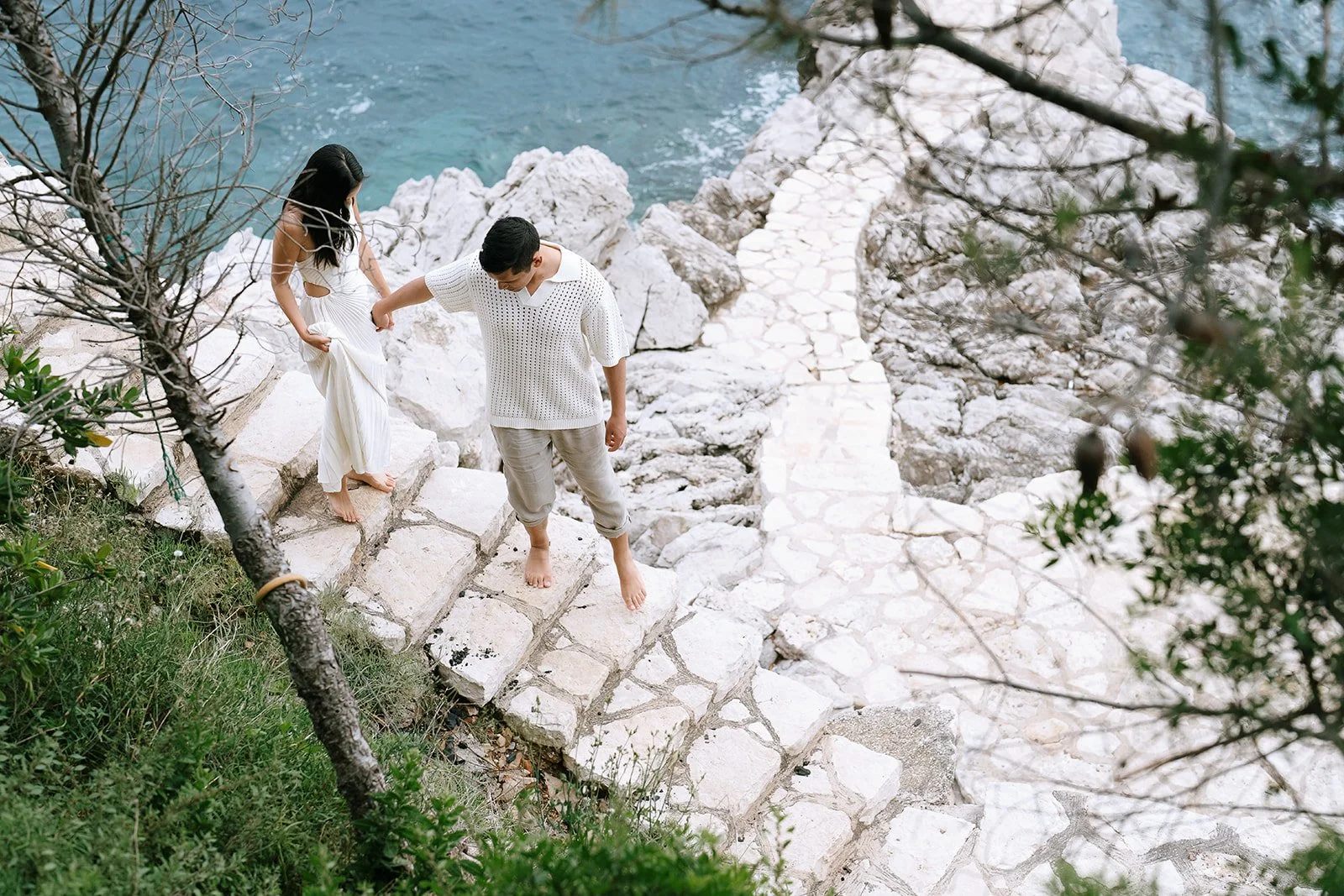 Couple walking down a cobblestone path to the Mediterranean Sea near the Bay of Villefranche on the French Riviera