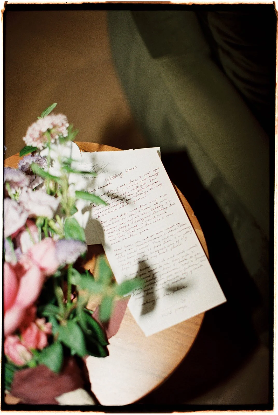  A glimpse at the wedding vows shadowed by the bridal bouquet. 35 mm film. 