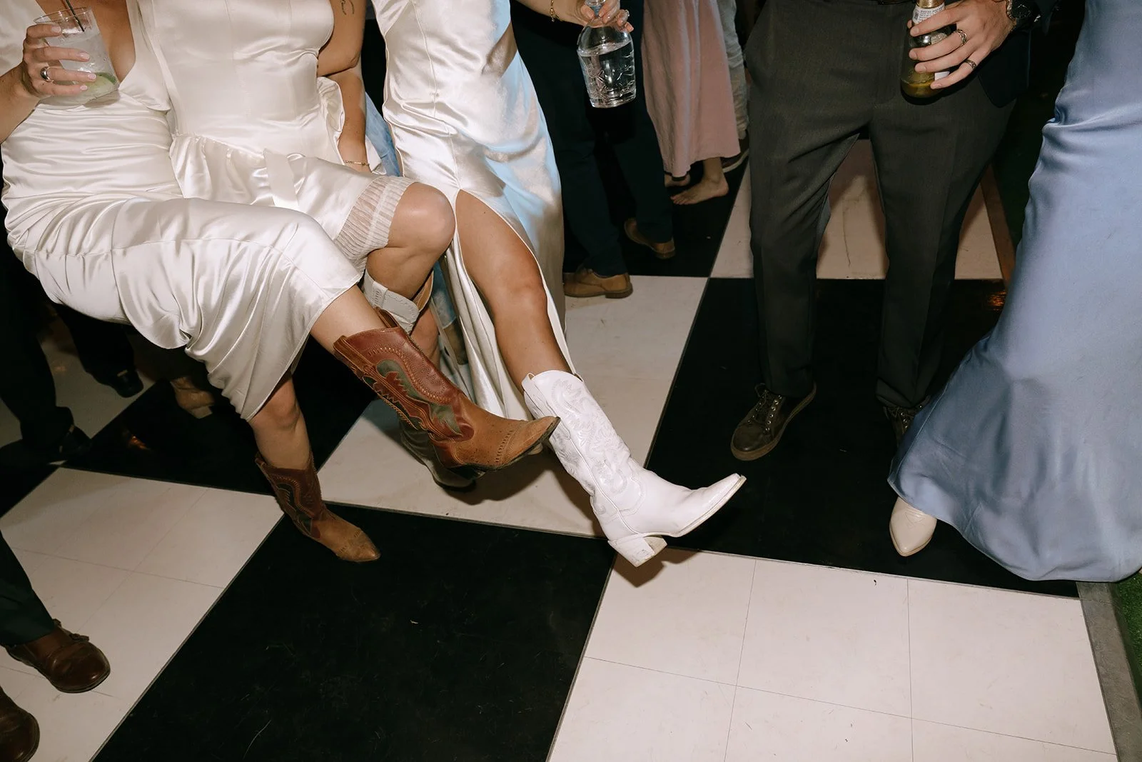 Cowgirl boots dancing on checkered wedding dance floor