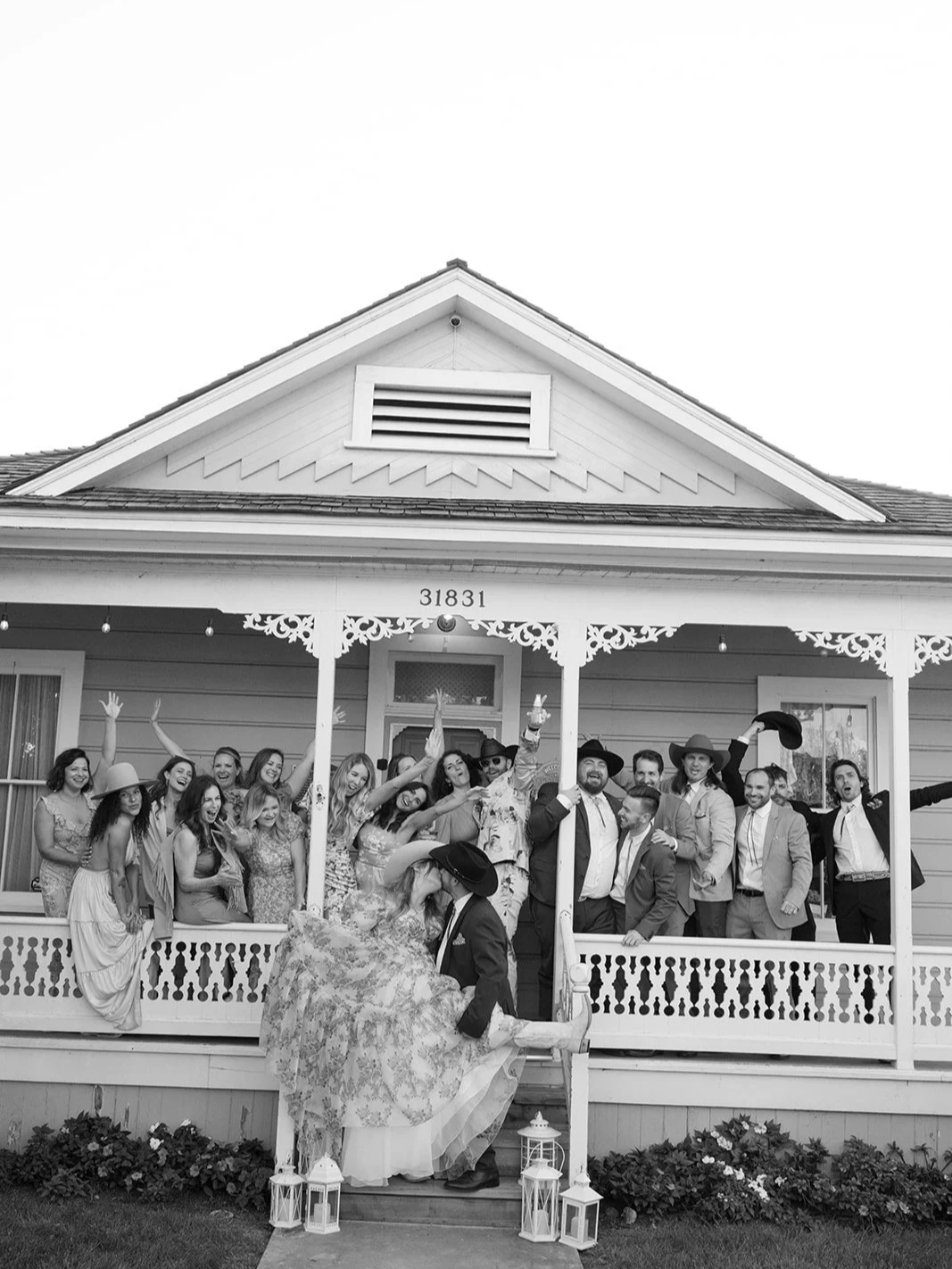 A group photo as the bride and groom kiss.