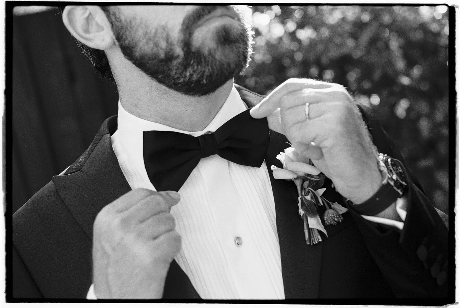  The groom adjusting his bowtie. 35 mm film. 