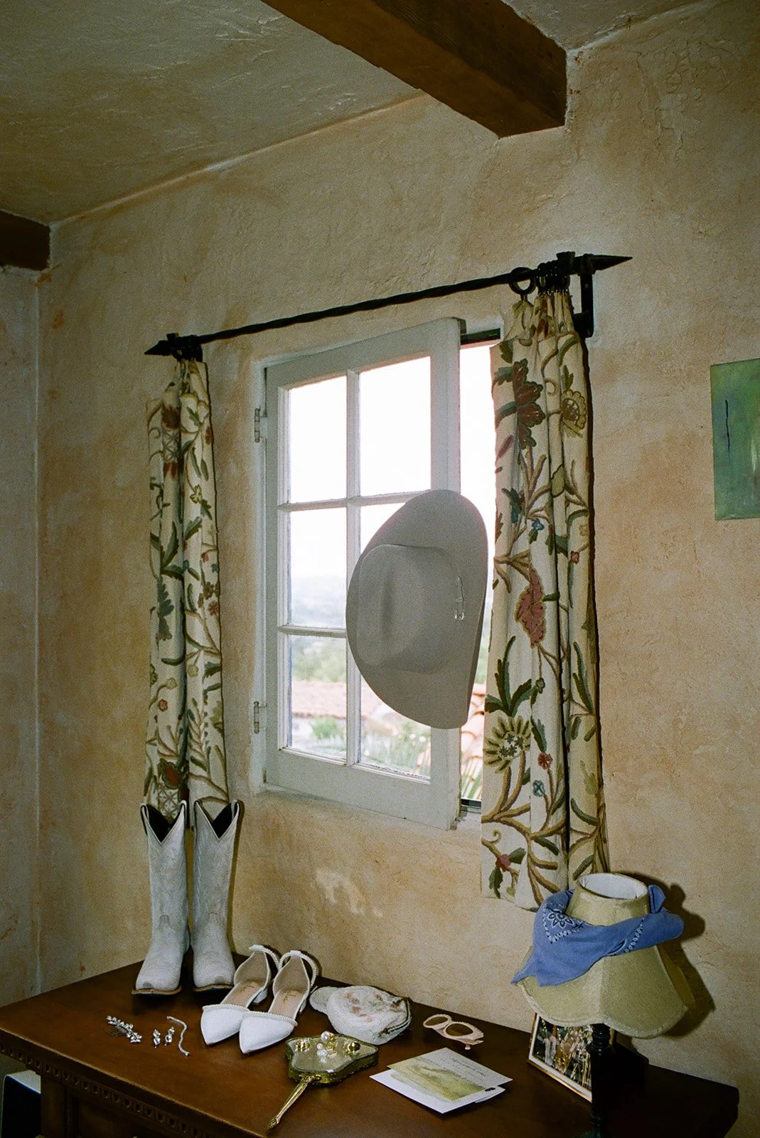 Getting ready details: bridal flats, cowgirl boots, tennis bracelet, pearl rings, vintage purse, sunglasses, vintage mirror, and invitation suite.