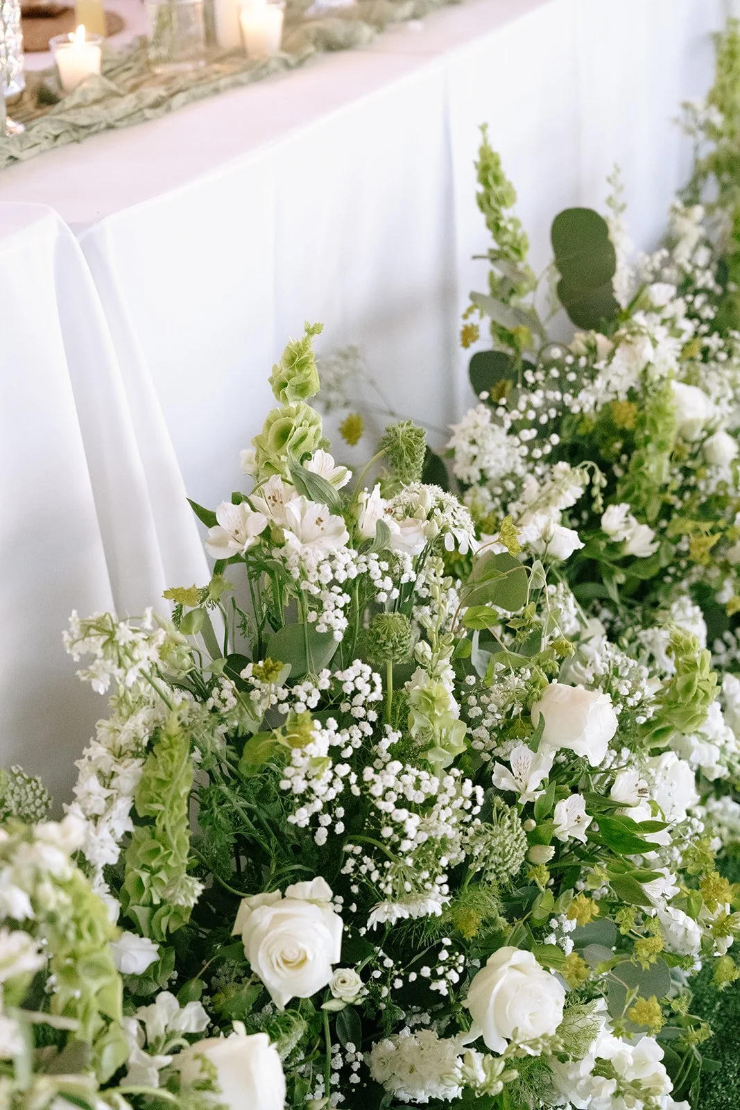 Reception details: White, garden-inspired florals line the head table.