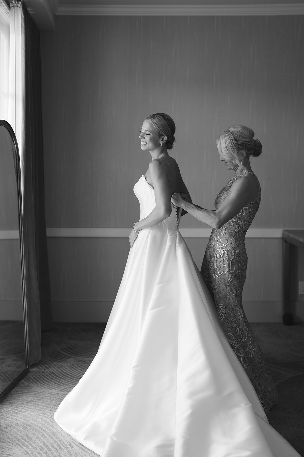 The bride having her dress zipped up