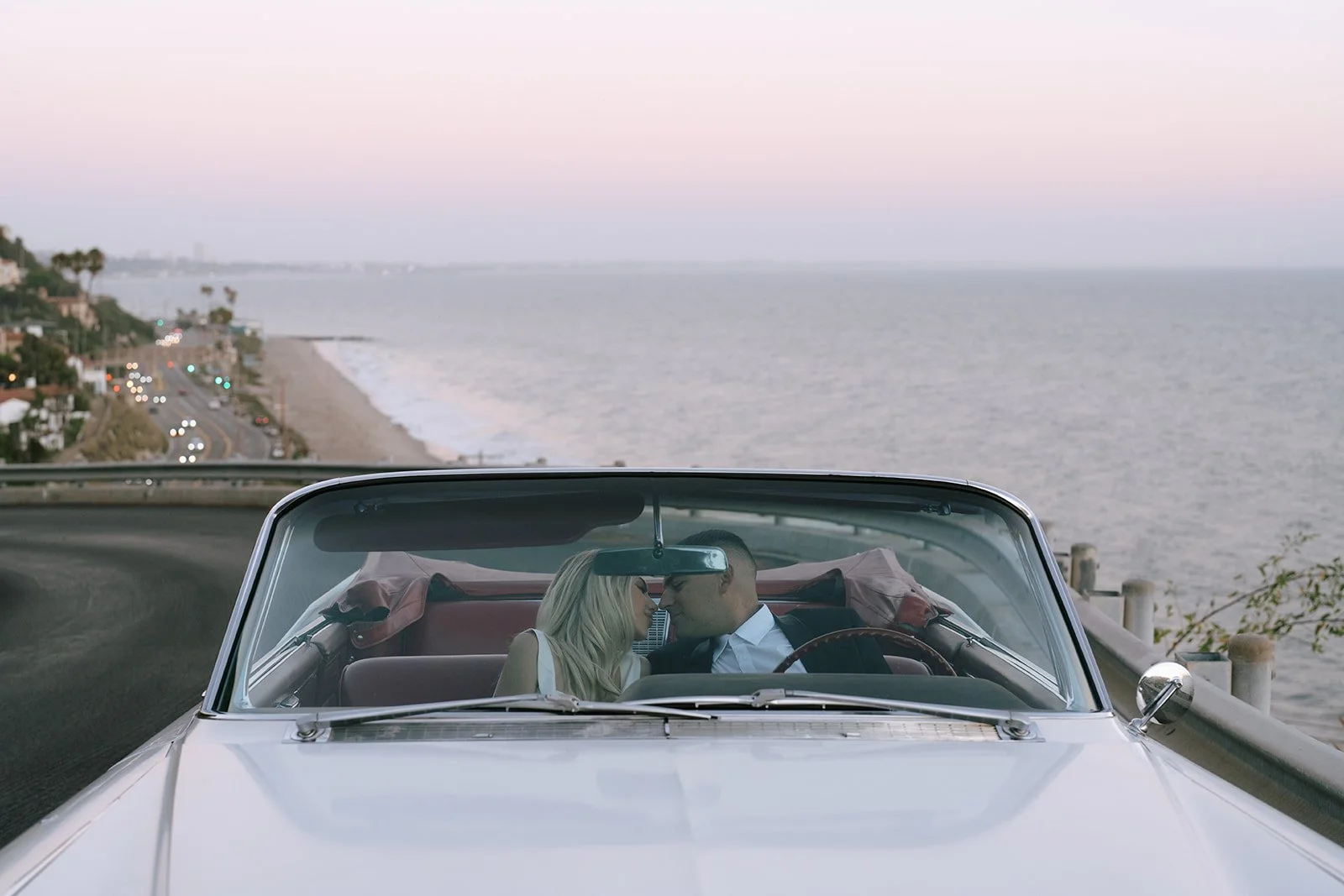 The couple in the car with the beach behind them