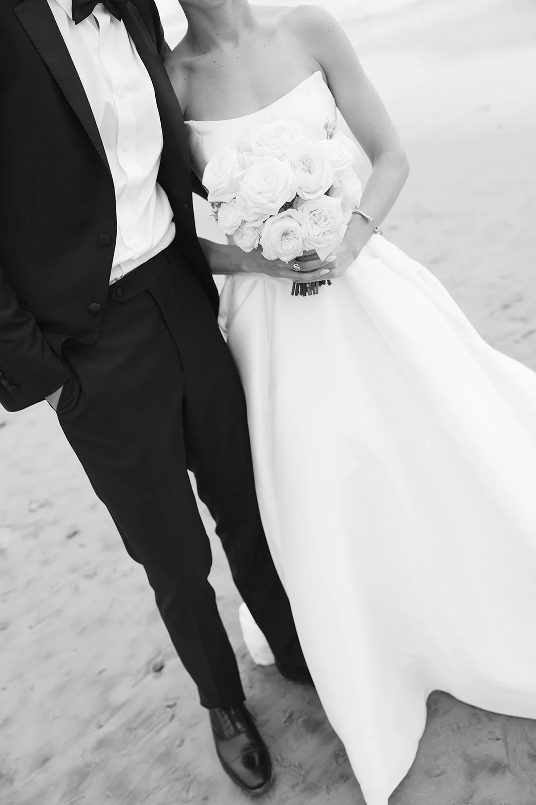 Close-up of the bride's gown and the groom's tuxedo.
