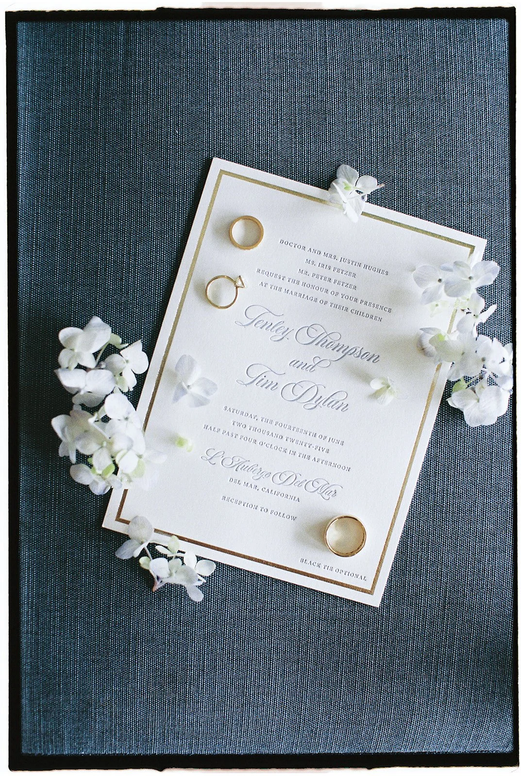 An invitation with flowers and wedding rings around it