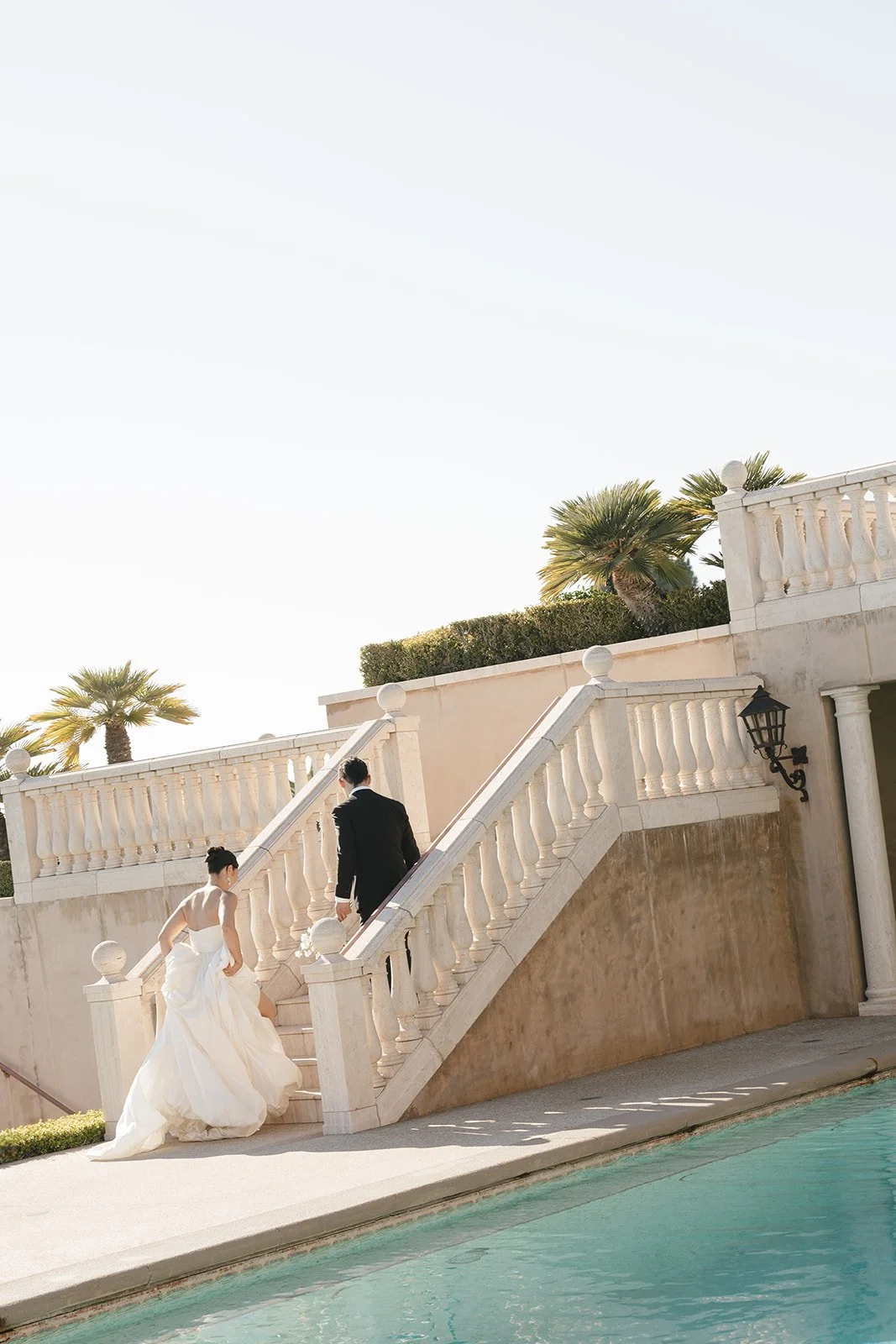 The bride and groom going up stairs.