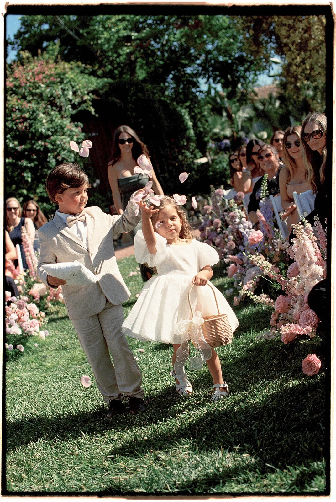  The flower girl and ring bearer making their way down the aisle. 35 mm film. 