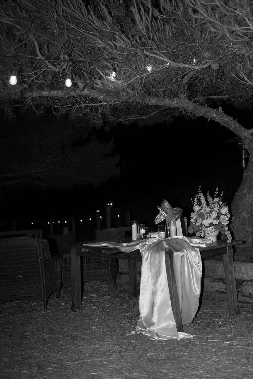 Reception details: guest welcome table  with oversized satin bow, modern floral arrangement and candles. Analog 35 mm film.