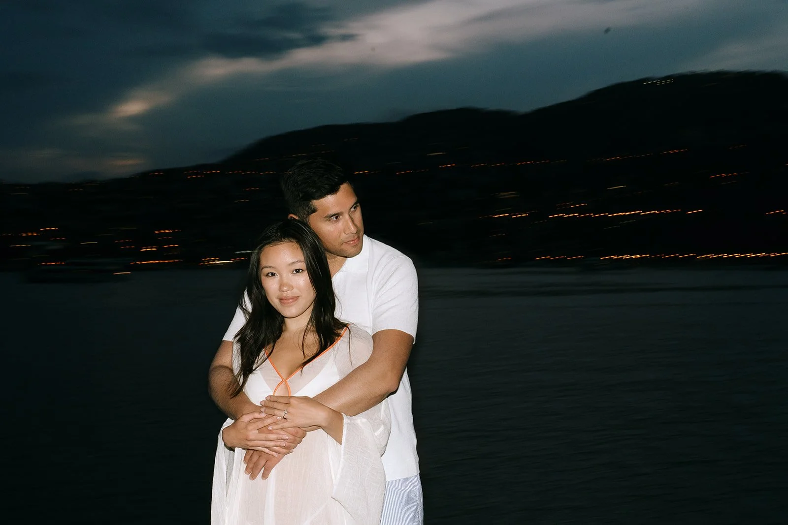 Couple smiling at each other at night on the French Riviera on the Saint-Jean-Cap-Ferrat coastline during their destination engagement photoshoot