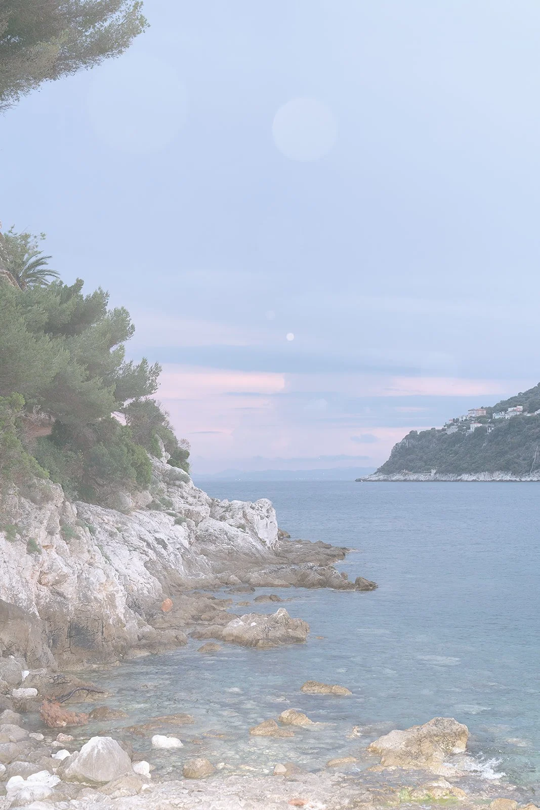 Sunset on the Passable Beach with a view of the Villefranche-sur-Mer across the Bay of Villefranche on the French Riviera