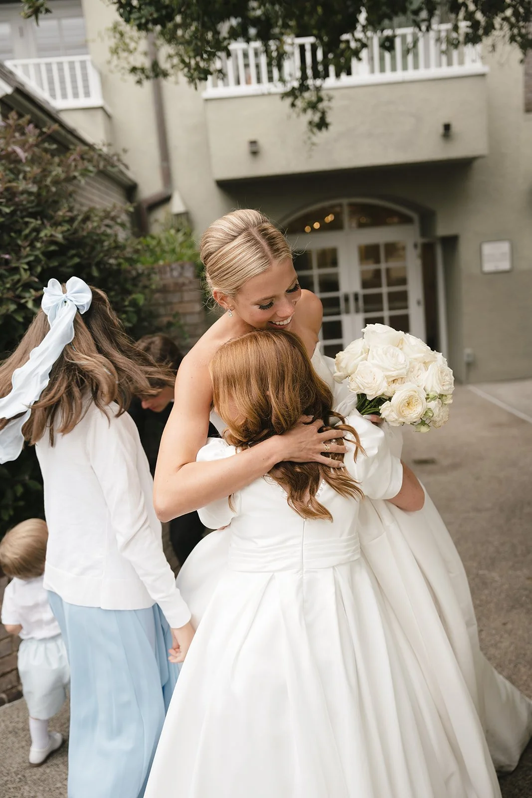 A hug shared between the flower girl and bride.
