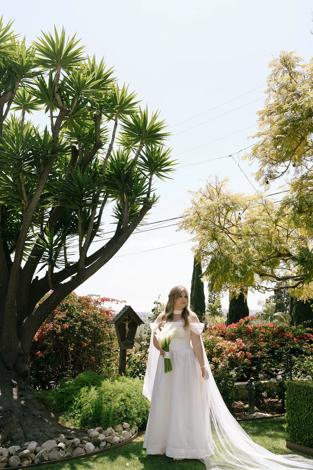 A bridal portrait before the wedding. Vintage structured wedding gown and cala lillies and bridal scarf.