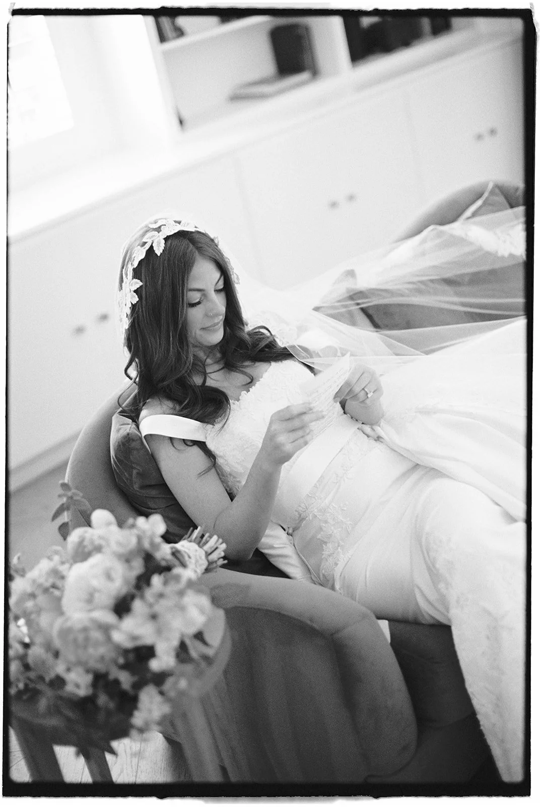  The bride taking a moment to read a handwritten note. 35 mm film. 