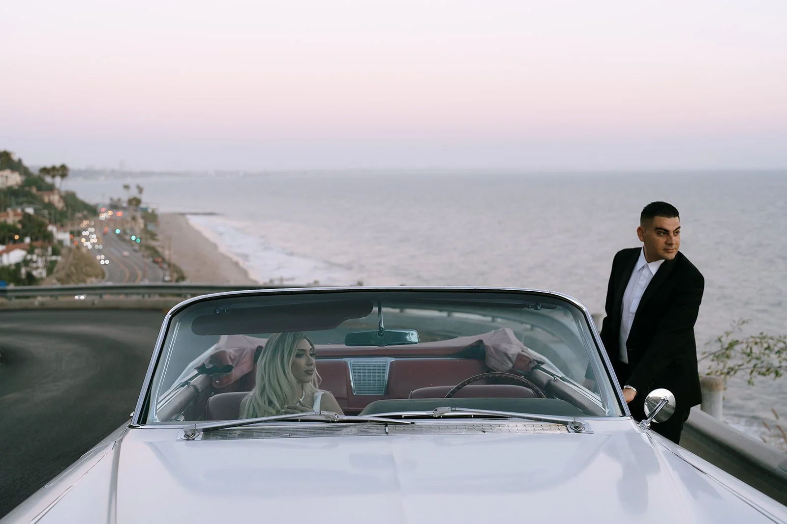 The couple in the car with the beach behind them