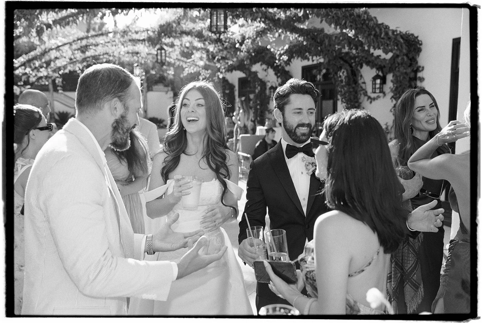  Bride and groom join cocktail hour and greet their wedding guests. 35 mm film. 