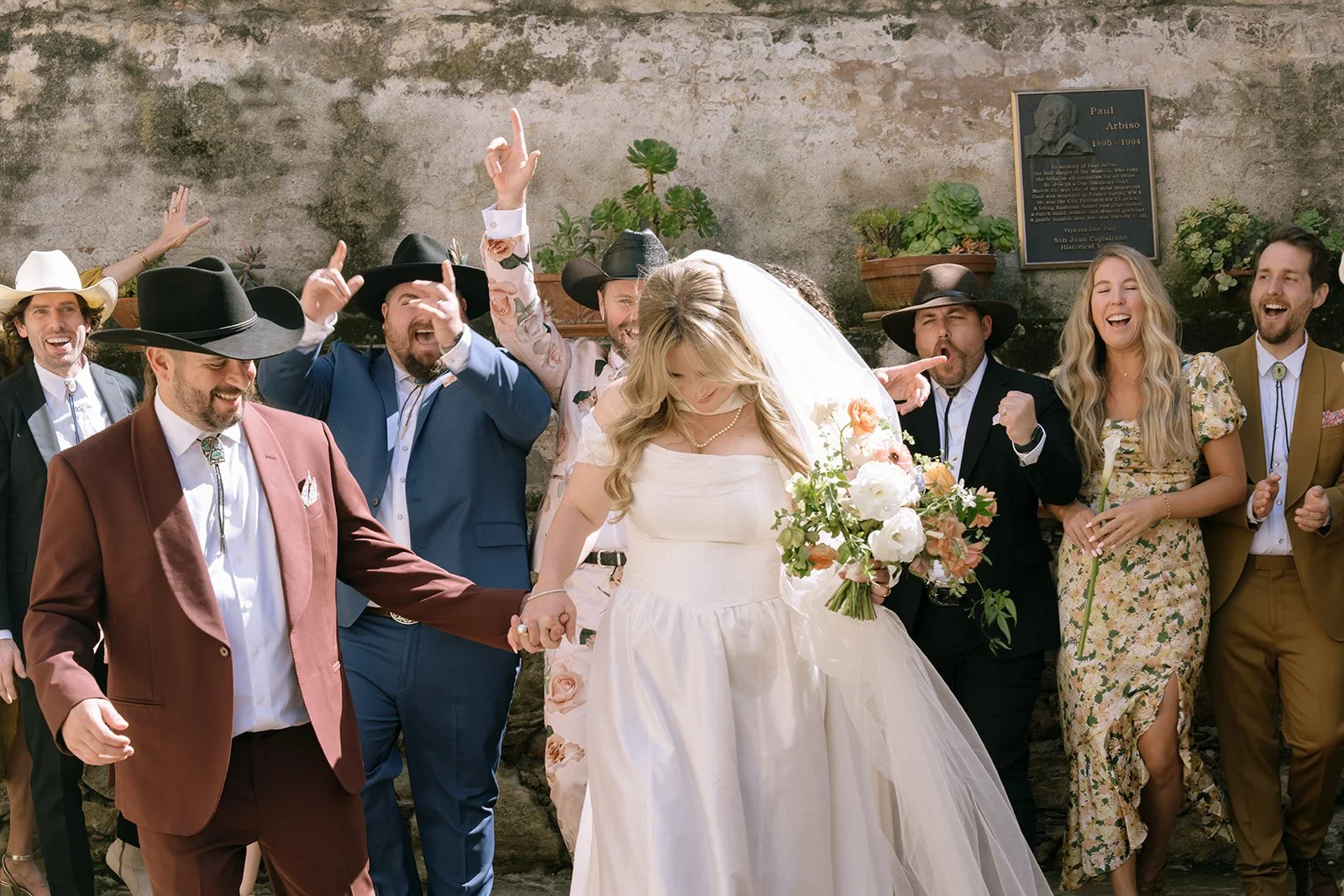 Wedding party portraits where everyone is cheering.