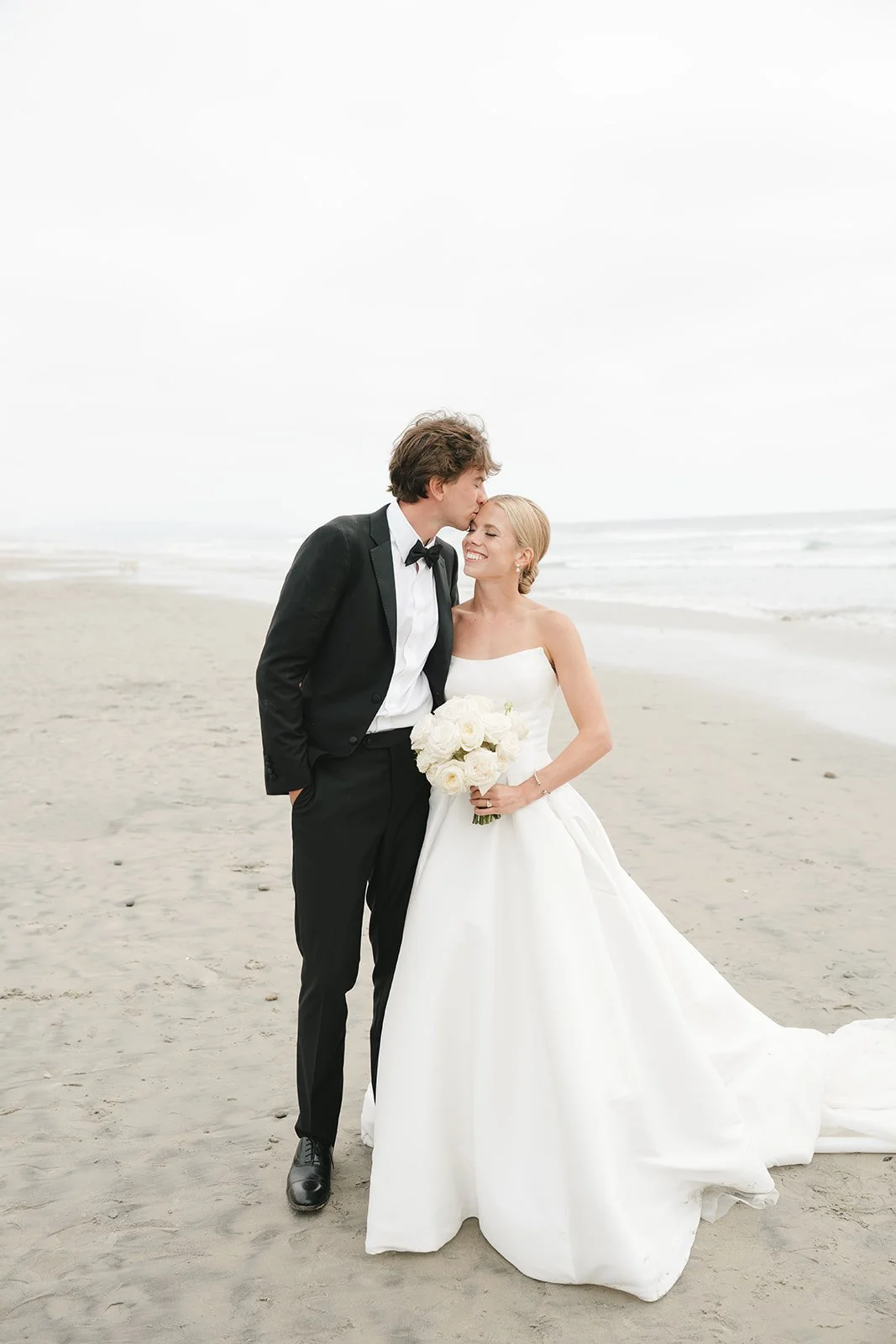 The groom kissing the bride's forehead.