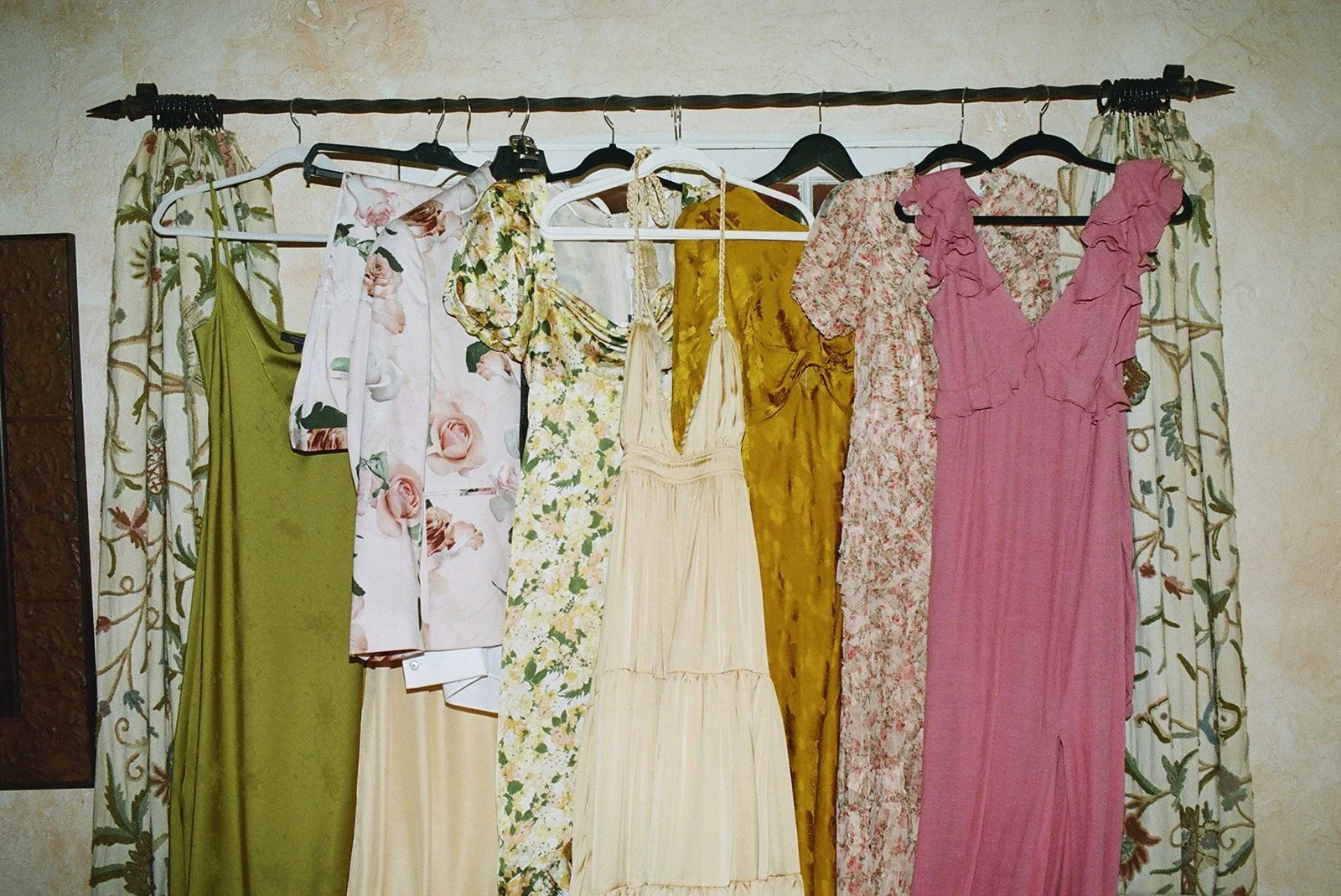 Colorful clothing hung on a curtain rod