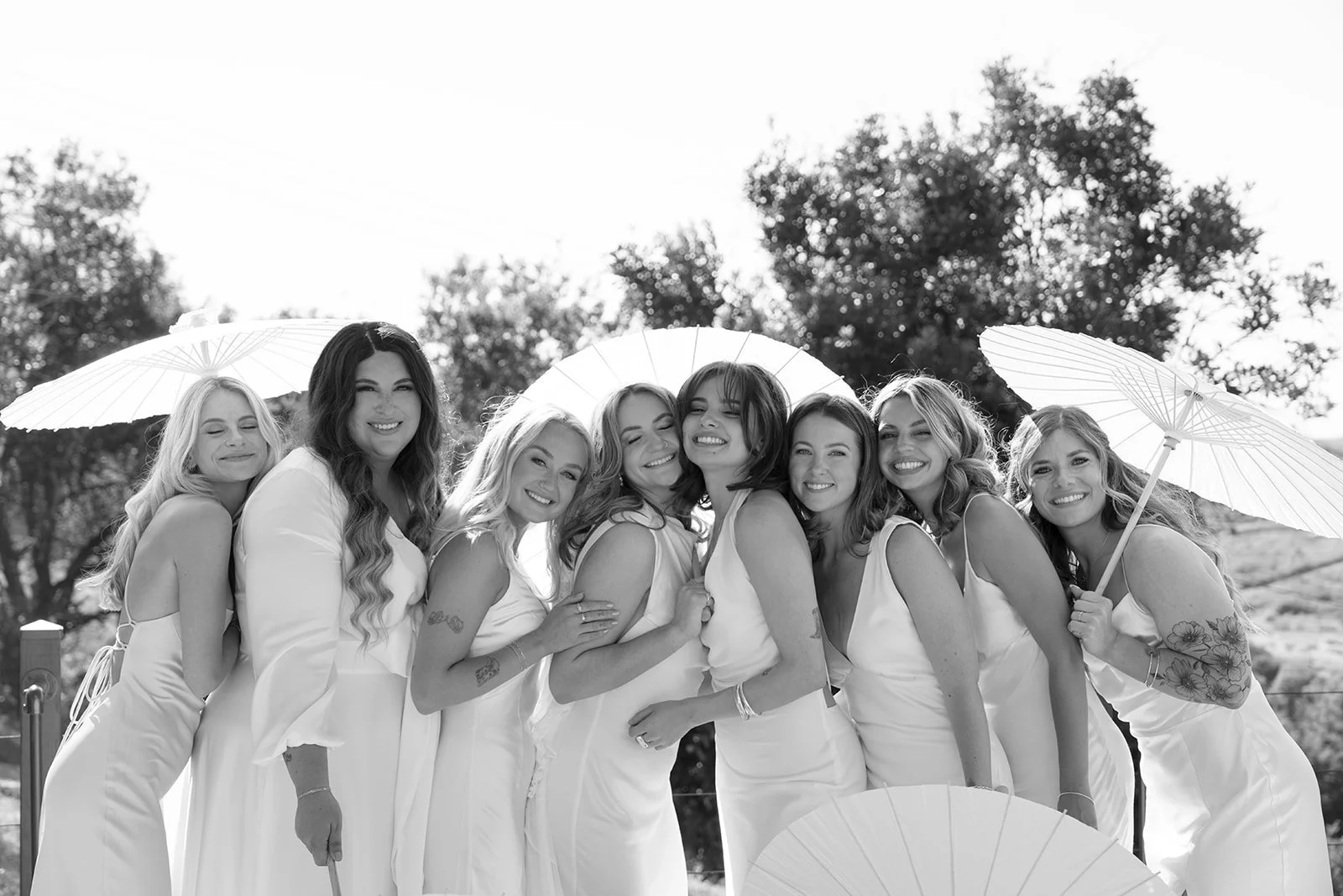 Bridal party with cream bridesmaids' gowns and matching parasols -- timeless wedding trends.
