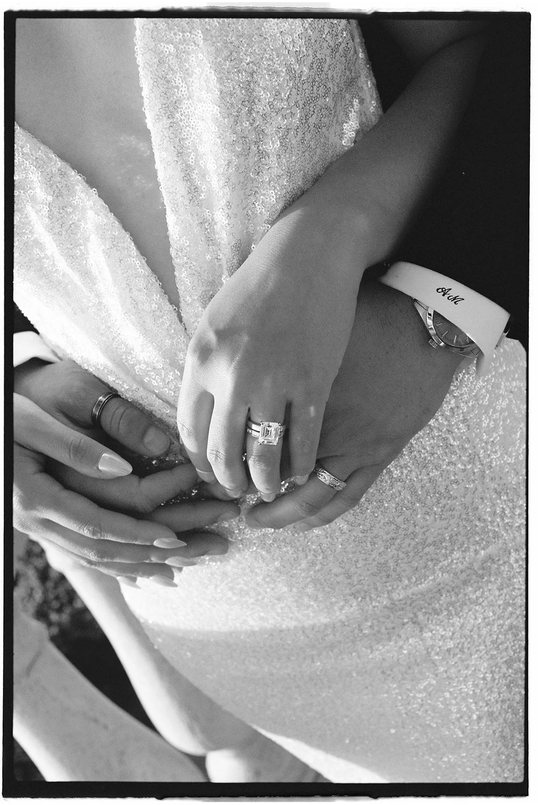 A close-up of the wedding rings, the brides second look, and the grooms monogrammed shirt.