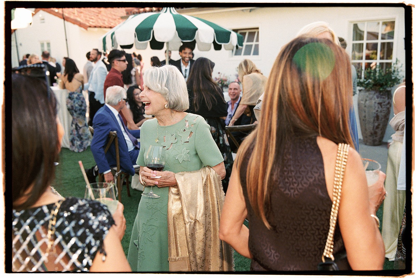  The wedding guests enjoying themselves during cocktail hour. 35 mm film. 