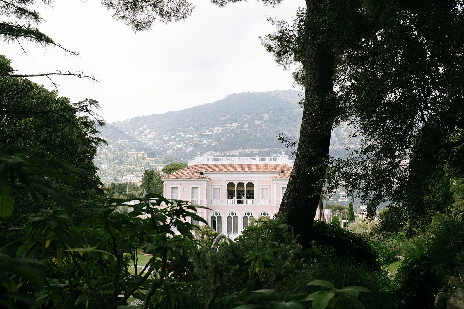 A view of the Villa Ephrussi de Rothschild through the lush greenery of the gardens in Saint-Jean-Cap-Ferrat on the French Riviera