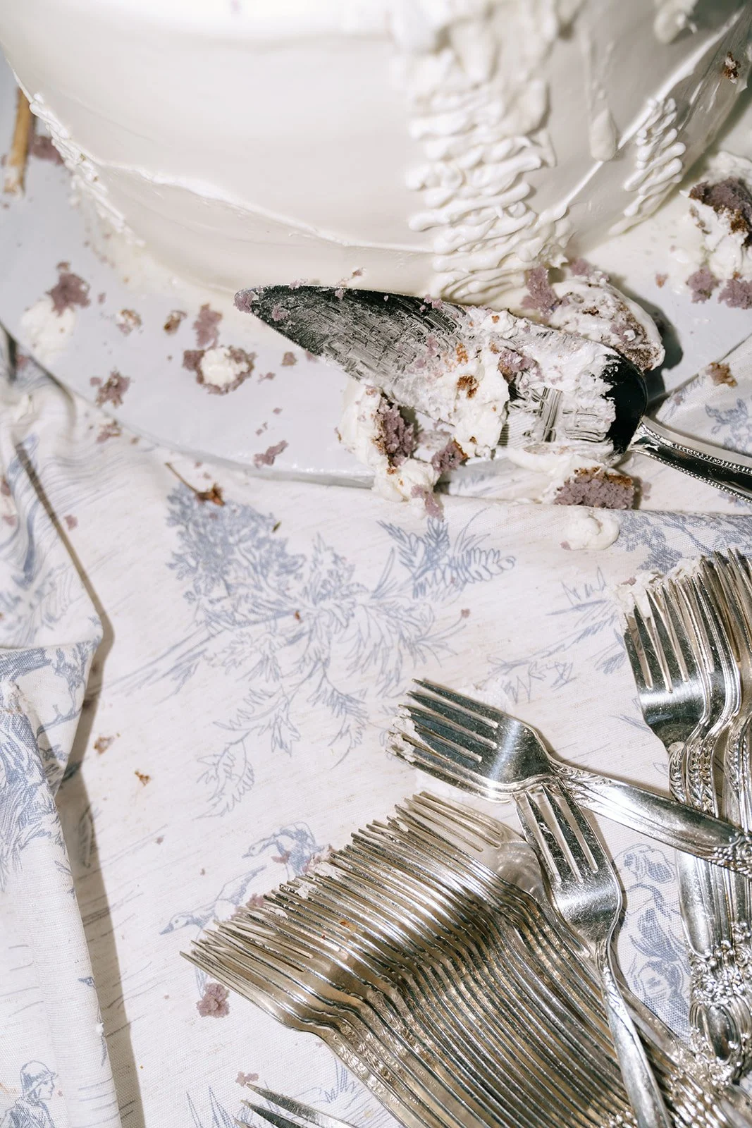 Messy details of the aftermath of the wedding cake cutting at the outdoor wedding reception in Big Bear California
