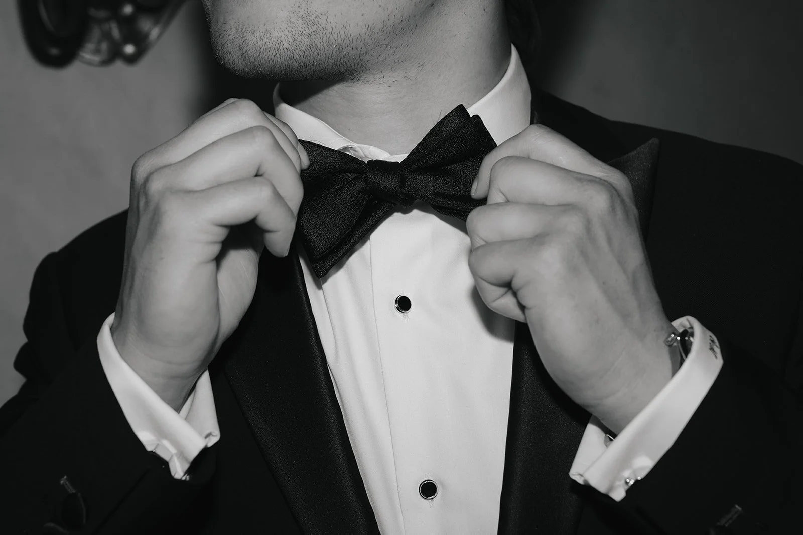 The groom adjusting his tie.