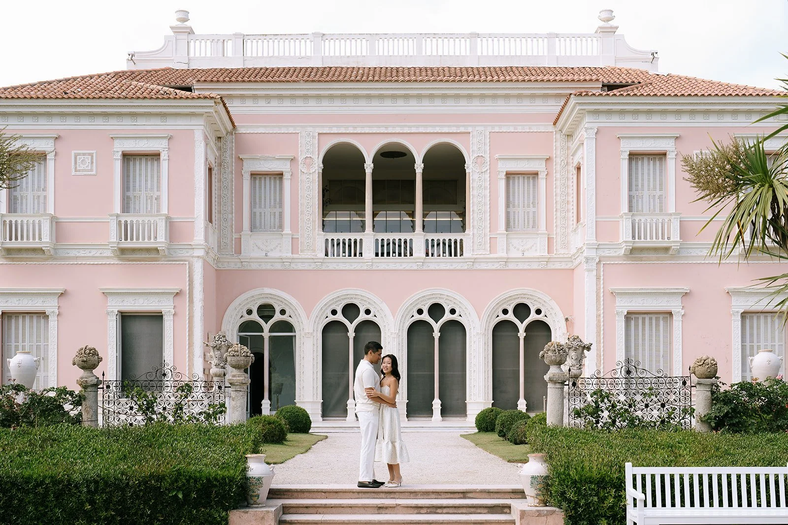 Soon to be bride and groom embrace in front of the Villa Ephrussi de Rothschild during their destination engagement session off the Cote d'Azur of the South of France