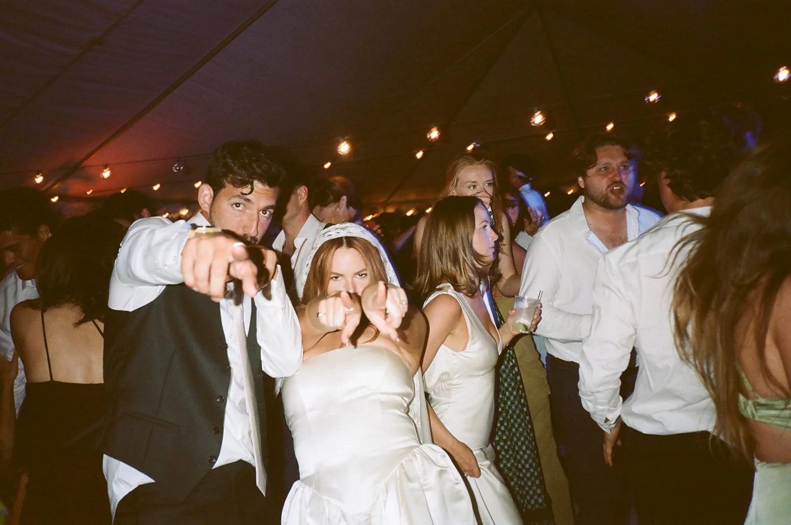 Bride and groom point to the camera